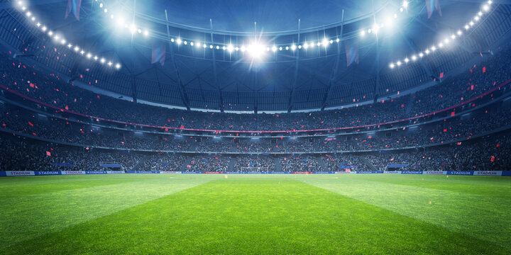 Stadion sepak bola besar dengan lampu terang di malam hari